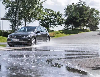 Ein Volkswagen Golf fährt auf nasser Fahrbahn bei einem Sicherheitstraining