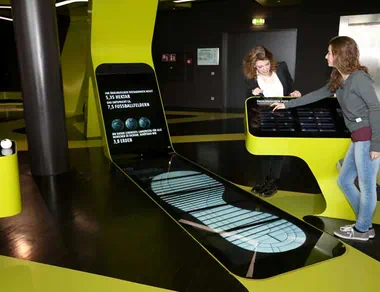 Zwei Frauen an einem interaktiven Exponat in der Ausstellung LEVEL GREEN