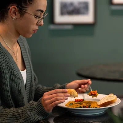 Frau isst Tellergericht in Restaurant