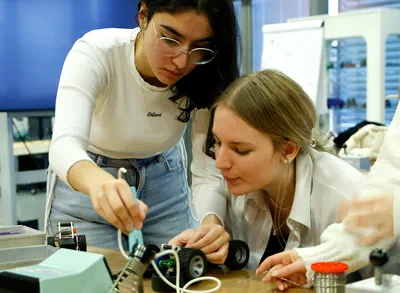 Zwei jugendliche Mädchen arbeiten gemeinsam an einem Workshop-Projekt in der Werkstatt