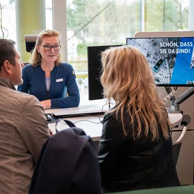 A couple talks to an employee of the Autostadt