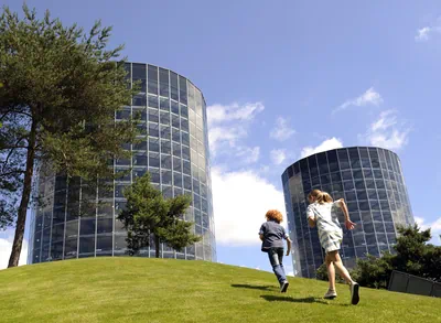 Zwei Kinder laufen über den Rasen auf die Autotürme zu