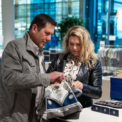 Frau und Mann die sich Volkswagen Bulli Tasche ansehen