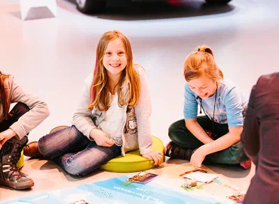 Lächelnde Kinder auf dem Boden im Pavillon sitzend