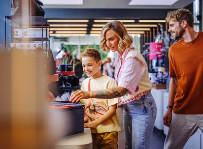 Eine Familie schaut sich die Produkte im moment! Shop der Autostadt an